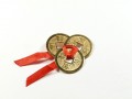 Trzy chińskie monety bogactwa przewiązane czerwoną wstążeczką